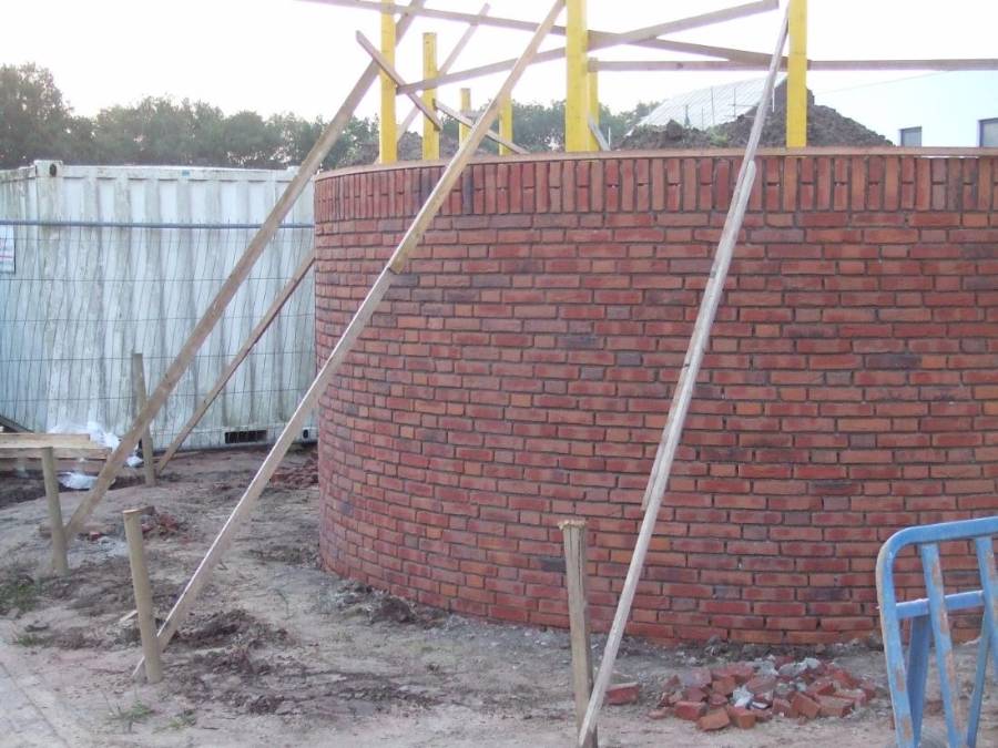 Rond gemetselde gevel in rode baksteen in aanbouw